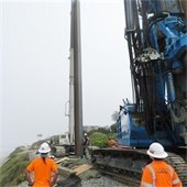 workers set piling on bluff