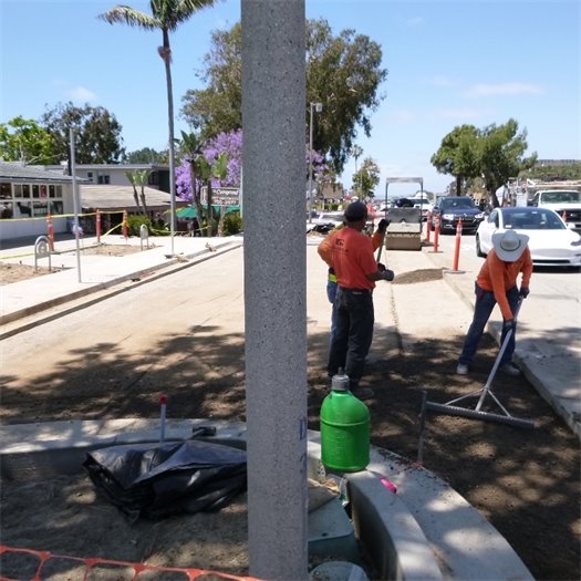 Workers grade a parking area on the 1200 block