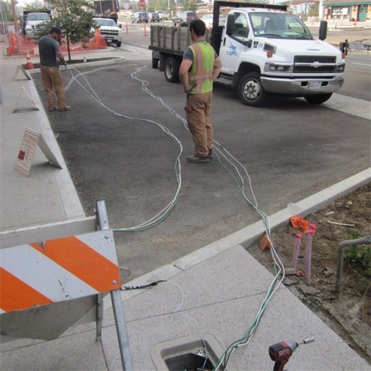 Electrical workers pull wire for streetlights.